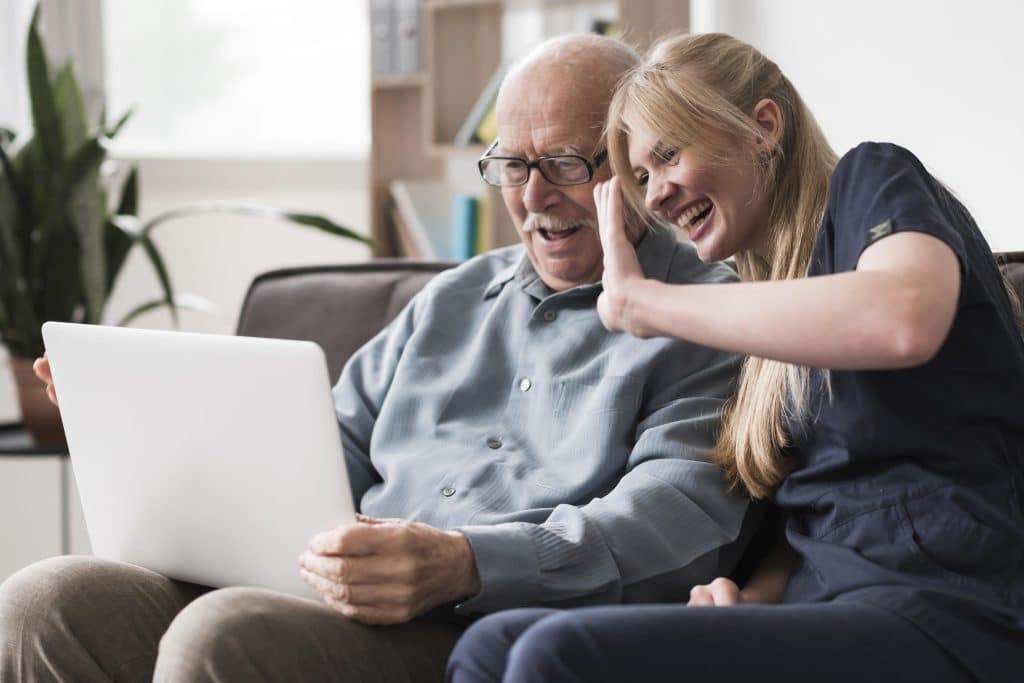 smiley-old-man-nurse-having-video-call-laptop